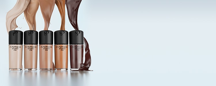 Model's hand holding MAC Cosmetics Studio Radiance Foundation. Swatch samples of various shades of foundation.